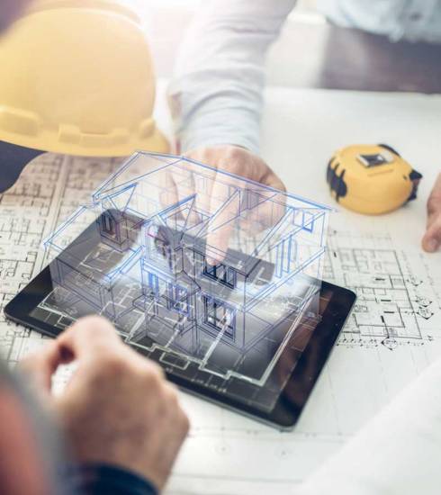 Constructores revisando planos con tablet y holograma; innovación en construcción
